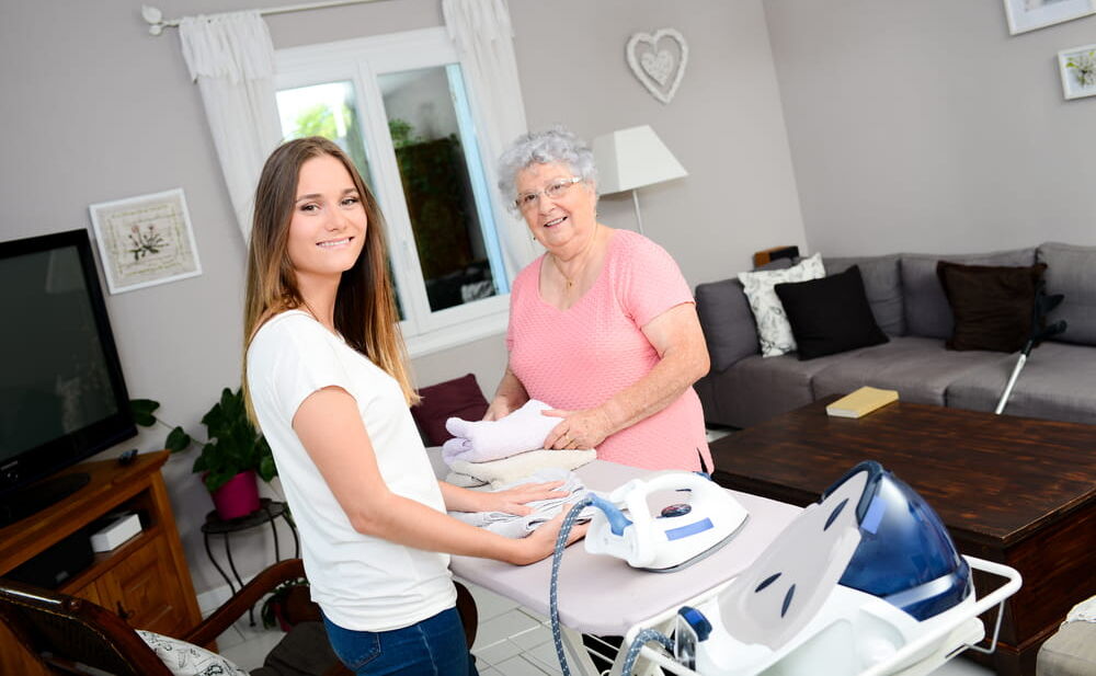 Girl ironing and helping with household chores - Umbrella Home Care